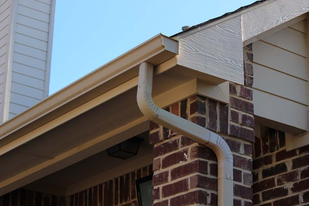 Roof gutters with a downspout on a residential house